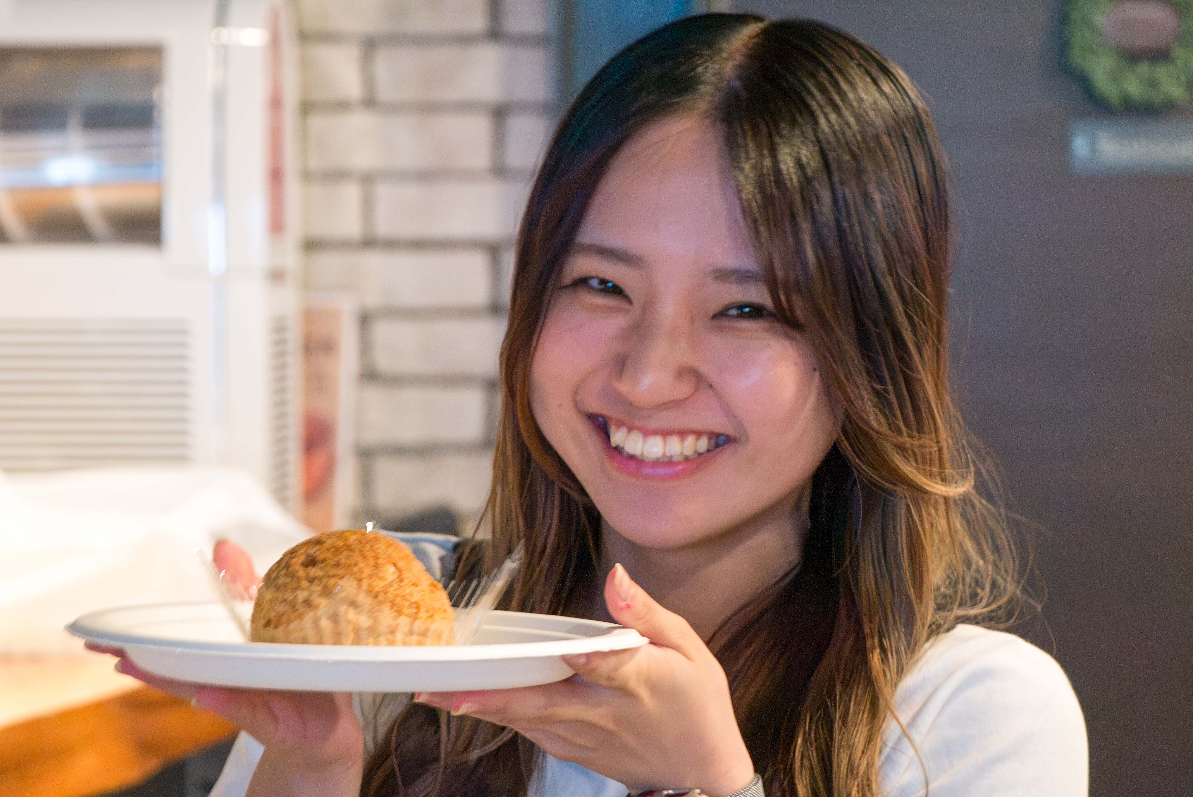 料理を手に笑顔の学生